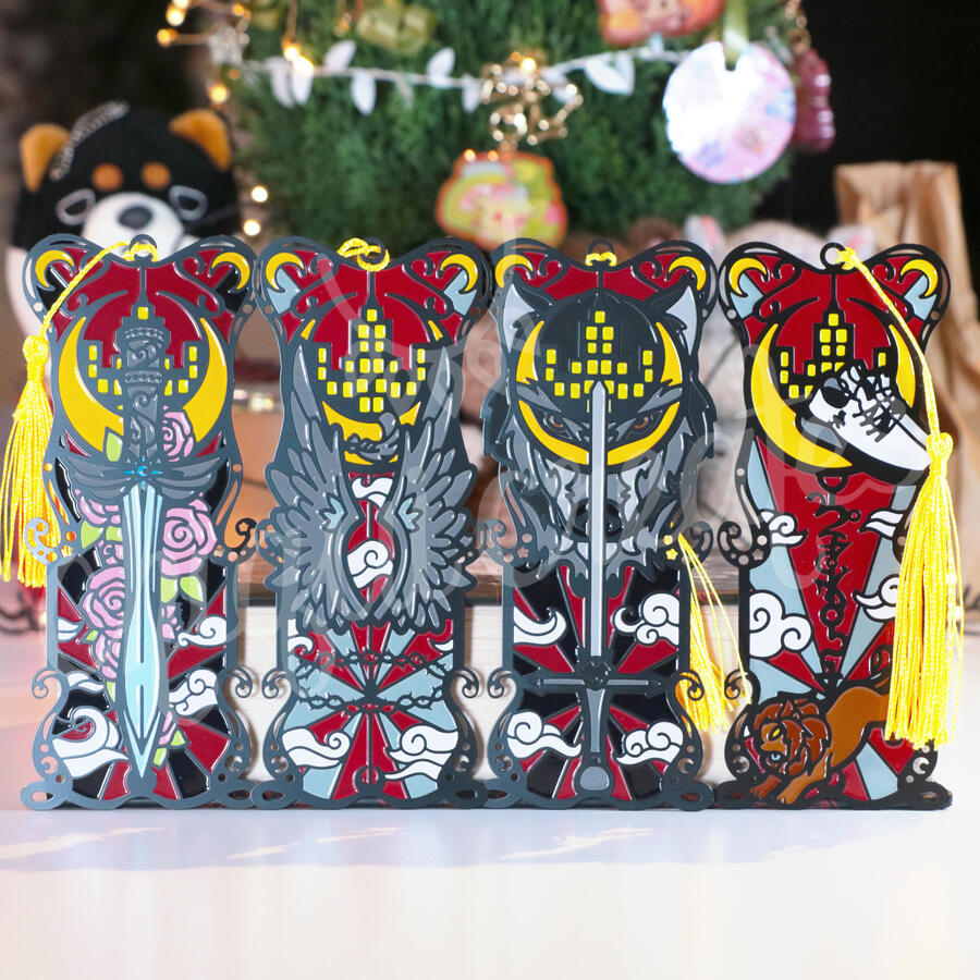 Four bookmarks featuring Crescent City illustrations. From left: the Starsword in front of roeses and a crescent moon, wings above a crown of thorns and behind a crescent moon, A sword in front of a wolf blended in with the crescent moon, and lastly shoes